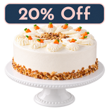 Carrot Cake on a white cake stand with the navy and pink 20% Off Treat Yourself Tuesday badge