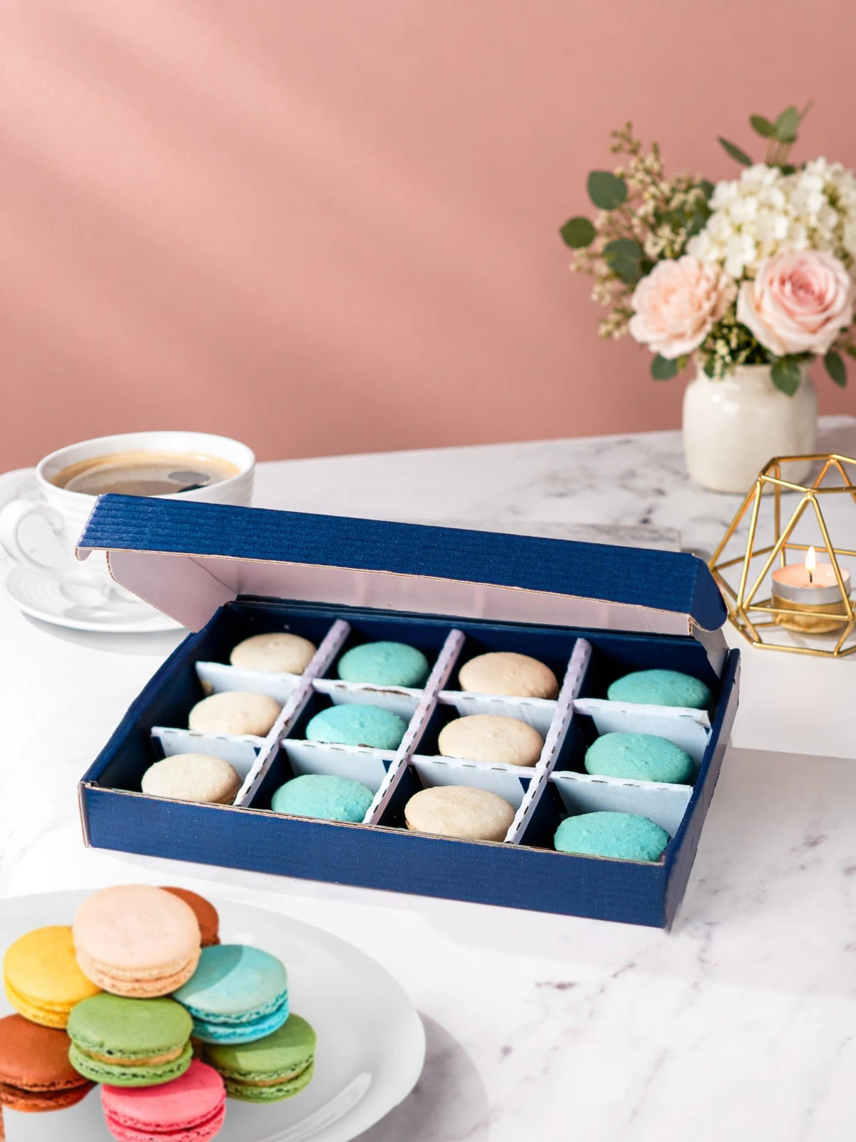 Open gift box of 12 blue salted caramel & vanilla macarons by Patisserie Valerie