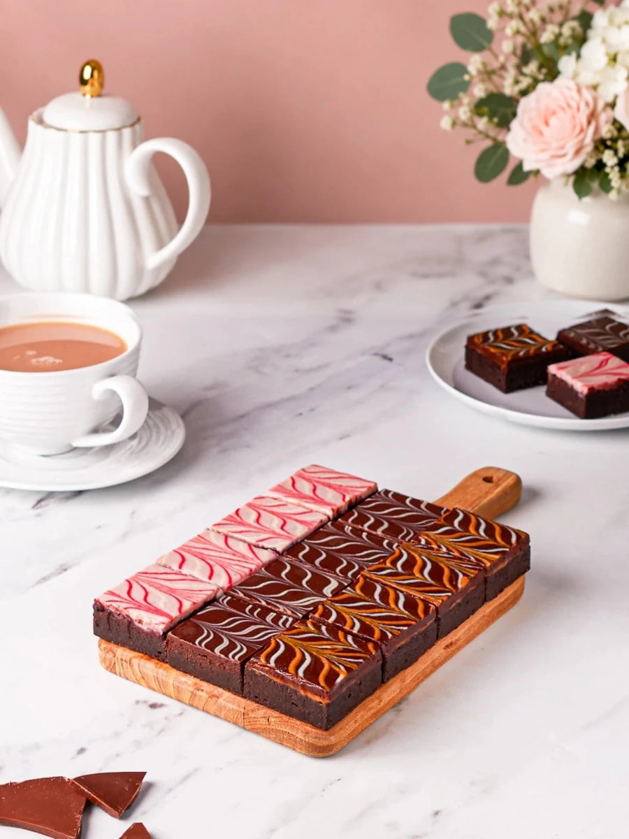 Chocolate fudge brownies arranged on a wooden serving board by Patisserie Valerie