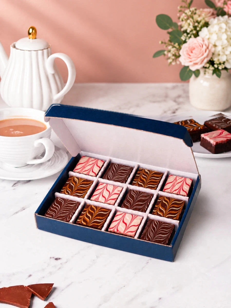 Chocolate fudge brownies arranged in an open gift box, viewed from the side by Patisserie Valerie
