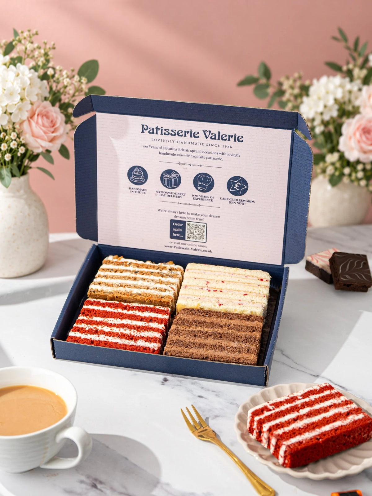 Favourites Quartet sponge cake slices in an open gift box with a slice on a plate by Patisserie Valerie