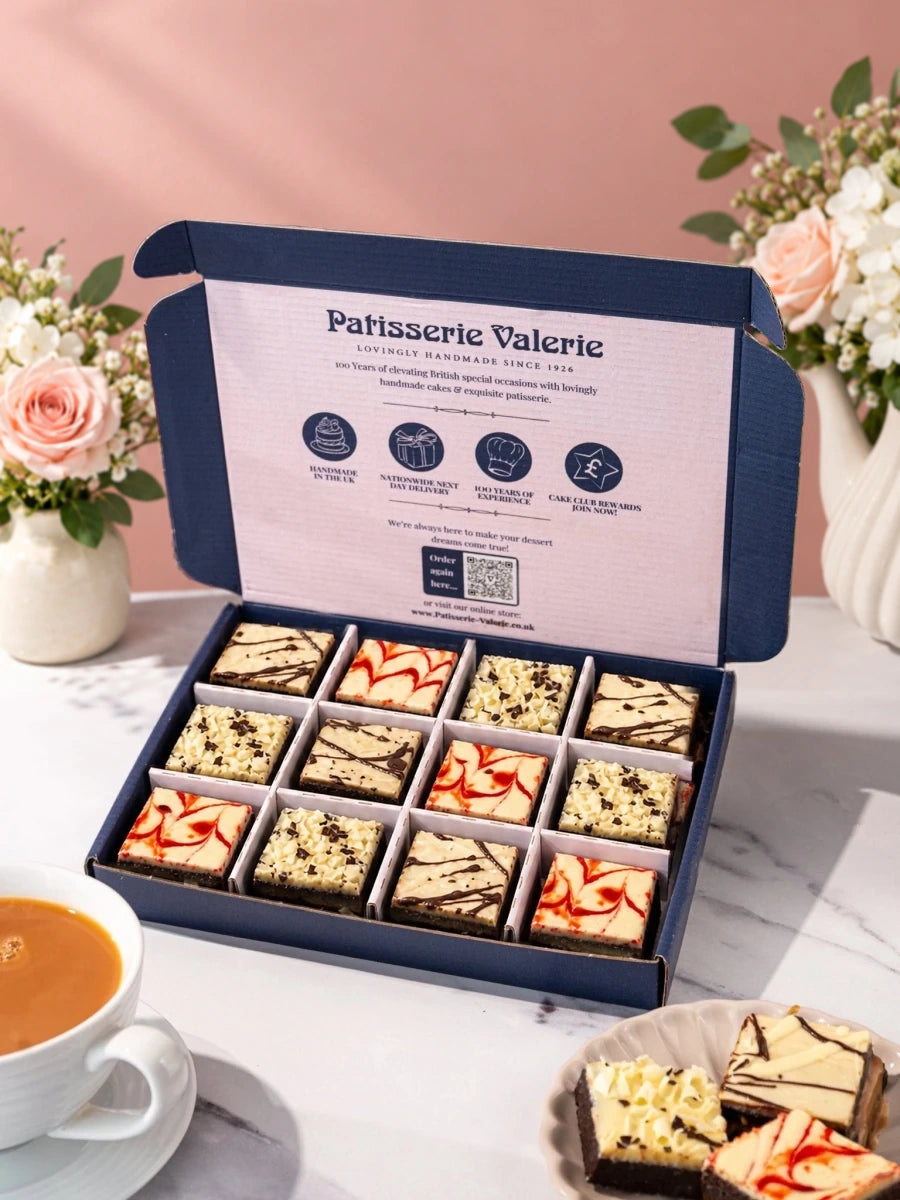 Assorted luxury brownies with decorative toppings in an open gift box by Patisserie Valerie