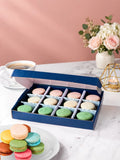 Open gift box of 12 pistachio, vanilla & rose macarons by Patisserie Valerie