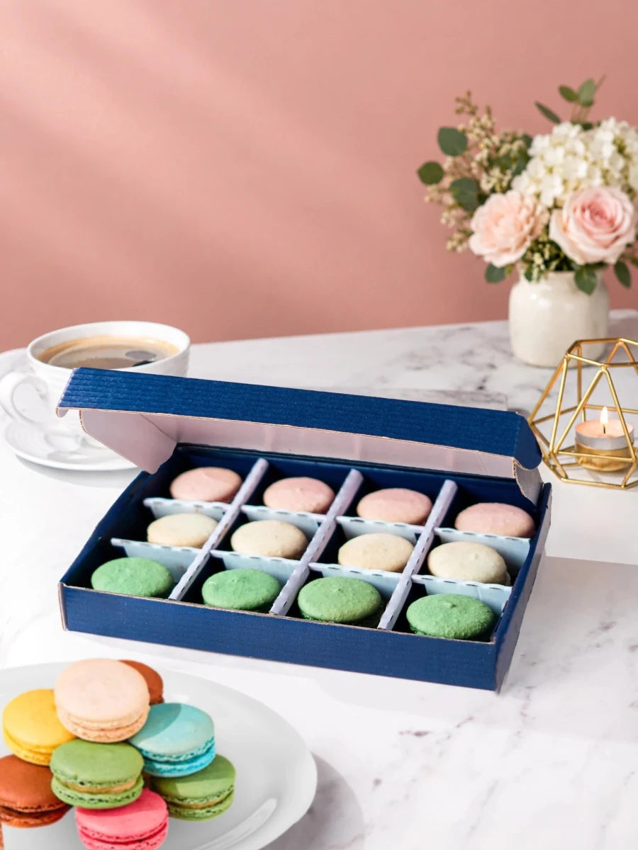 Open gift box of 12 pistachio, vanilla & rose macarons by Patisserie Valerie