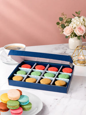 Open gift box of 12 pistachio, raspberry & salted caramel macarons by Patisserie Valerie