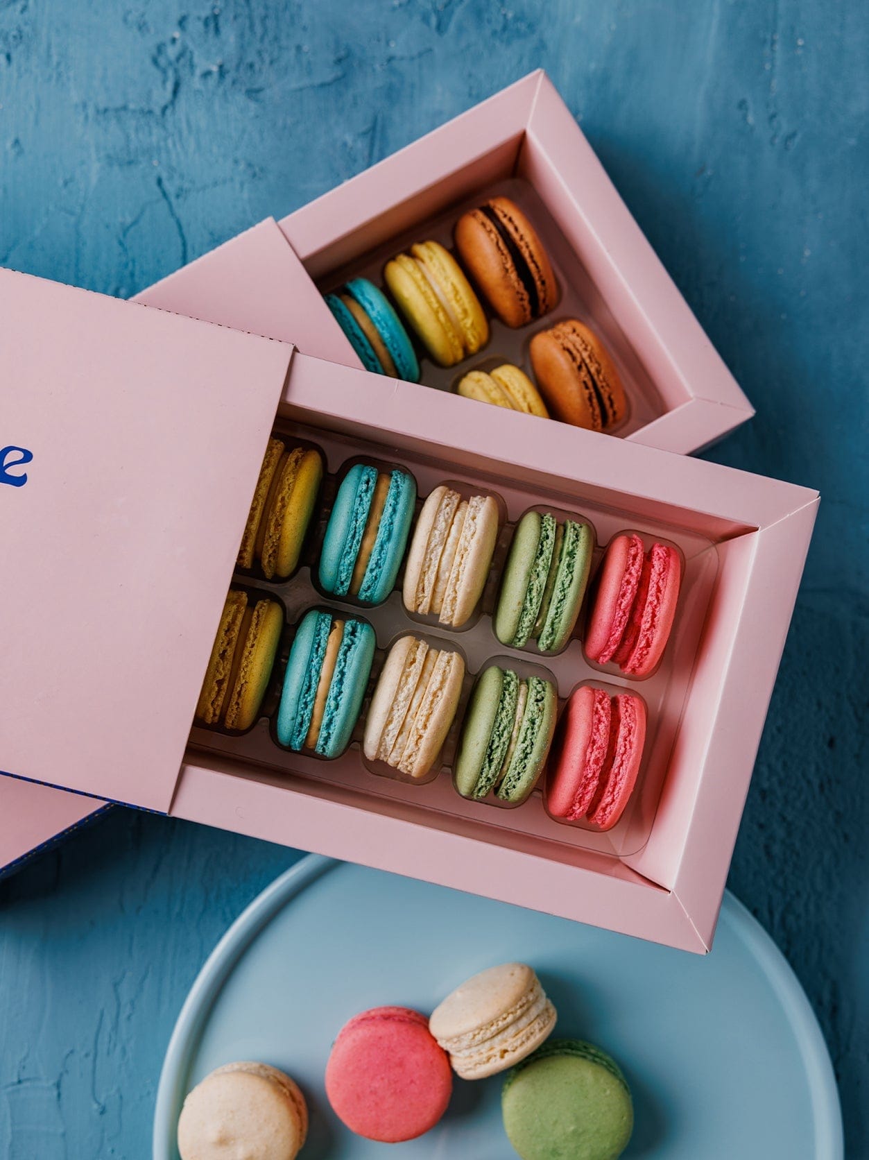 Patisserie Valerie's handmade Macaron Gift Box of 12 assorted macarons being unboxed and plated