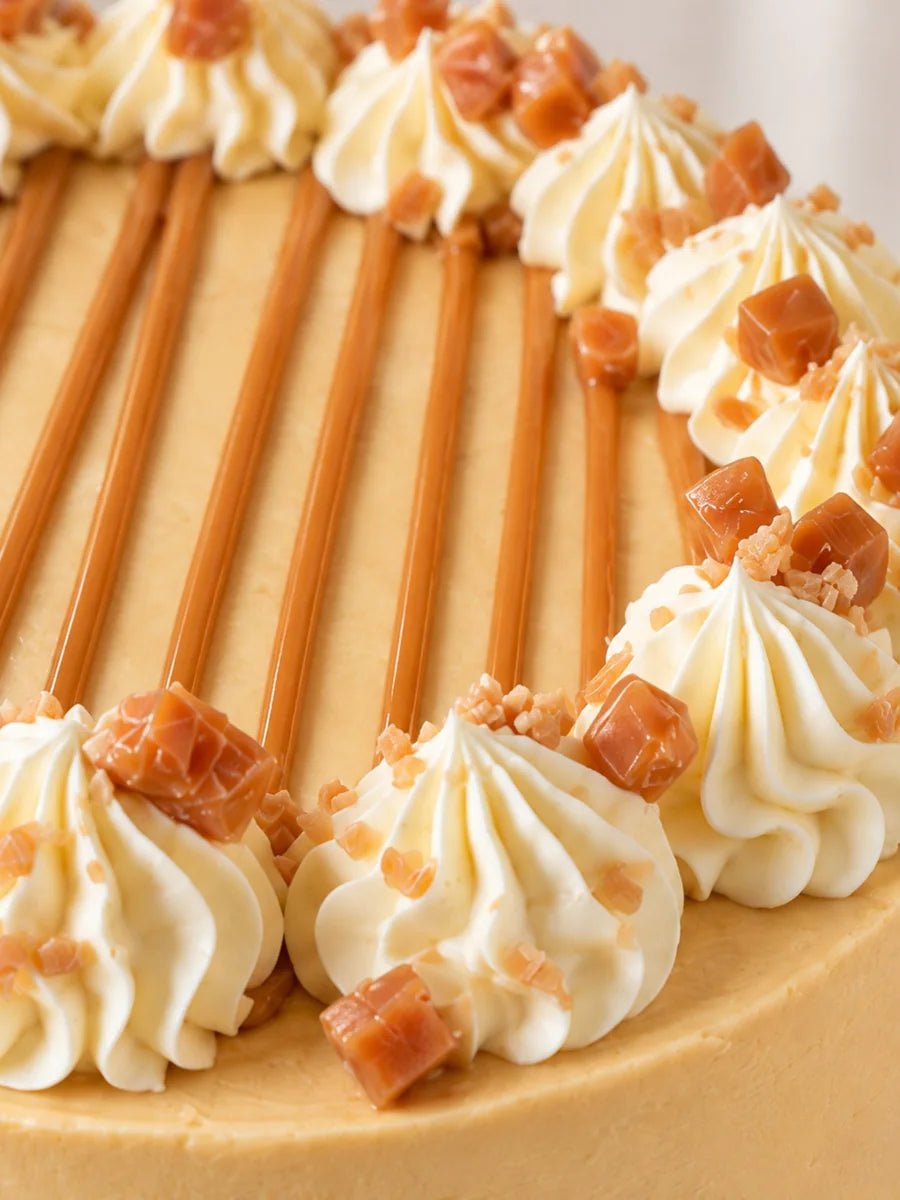 Glossy caramel drizzle, vanilla buttercream swirls and mini caramel fudge pieces on the Toffee Apple Celebration Cake