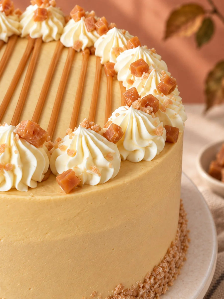 Close-up of the Toffee Apple Celebration Cake's toffee buttercream, cinnamon crumble base and fudge-topped vanilla piping